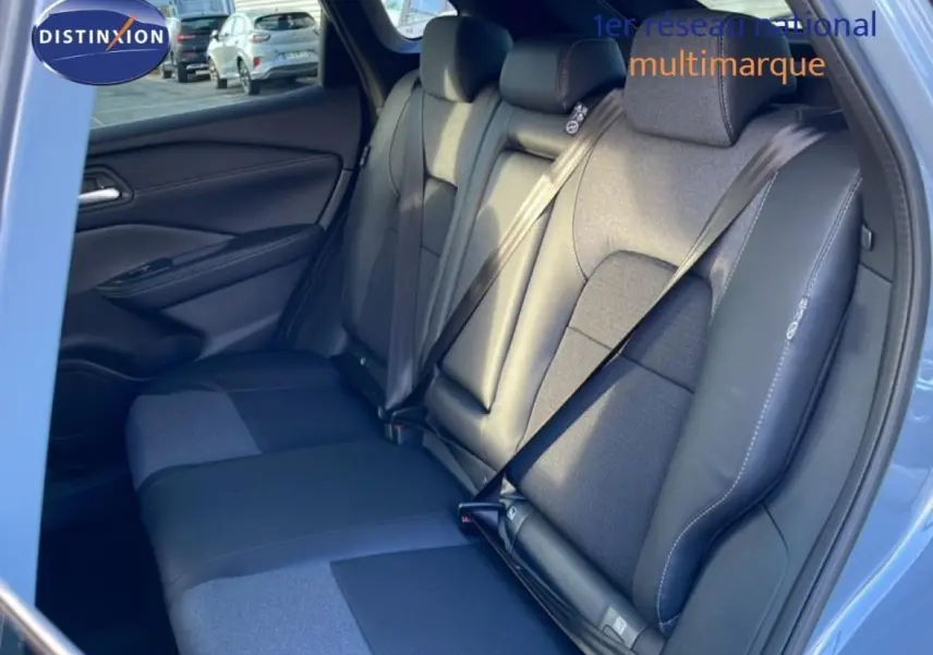 Vue intérieure côté droit des sièges arrière en cuir et tissu du Nissan Qashqai gris 2025, avec ceintures de sécurité visibles.