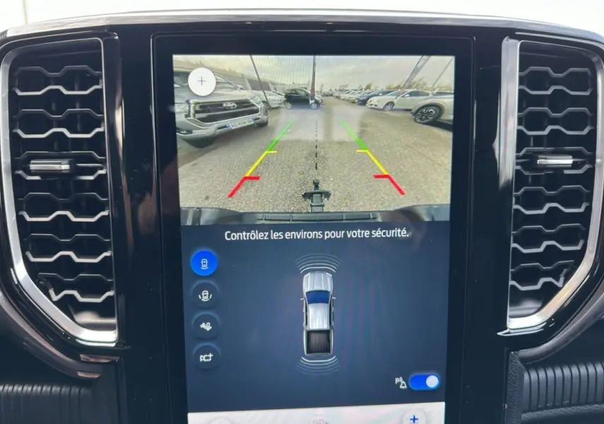 Écran tactile central du Ford Ranger gris montrant la caméra de recul et les capteurs de stationnement.