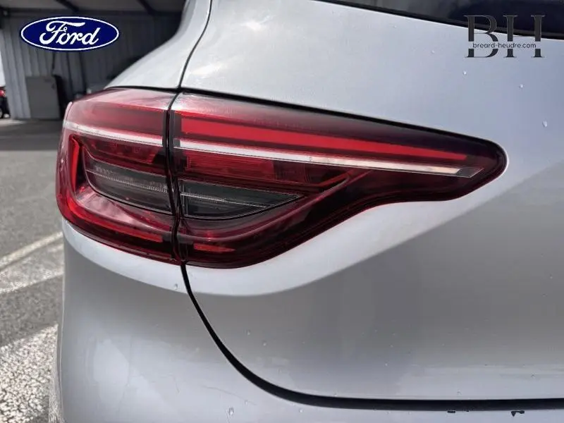 Gros plan sur le feu arrière droit d'une Renault Clio gris platine, soulignant les lignes modernes du véhicule.