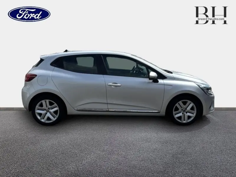 Profil droit d'une Renault Clio 1.0 TCe 100ch Business gris platine, avec jantes alliage et poignées ton carrosserie.