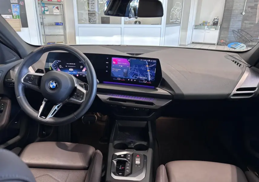Vue intérieure de face du poste de conduite de la BMW Série 1 120d M Sport 2025 avec écran numérique et volant multifonction.