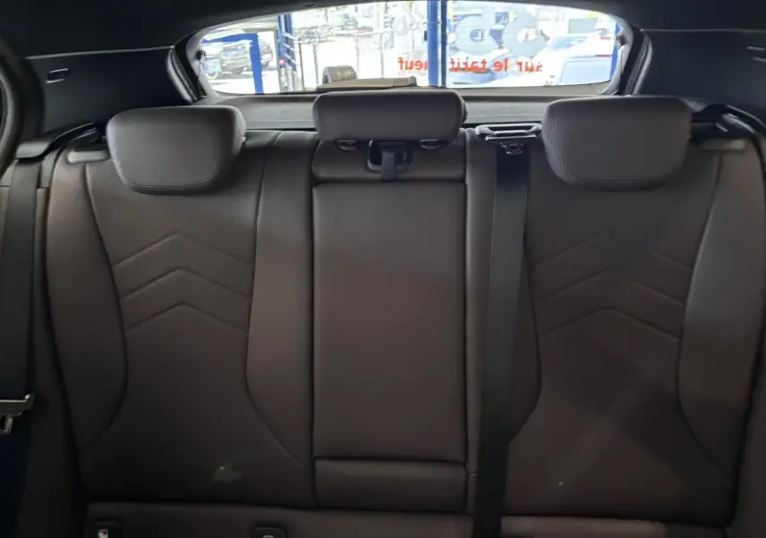 Vue intérieure des sièges arrière en cuir noir de la BMW Série 1 120d M Sport 2025, avec appuie-têtes et ceinture de sécurité.