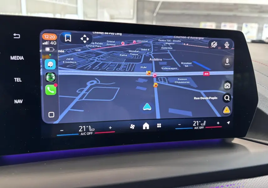 Écran tactile central de la BMW Série 1 120d M Sport 2025 montrant la navigation et la climatisation à 21°C.