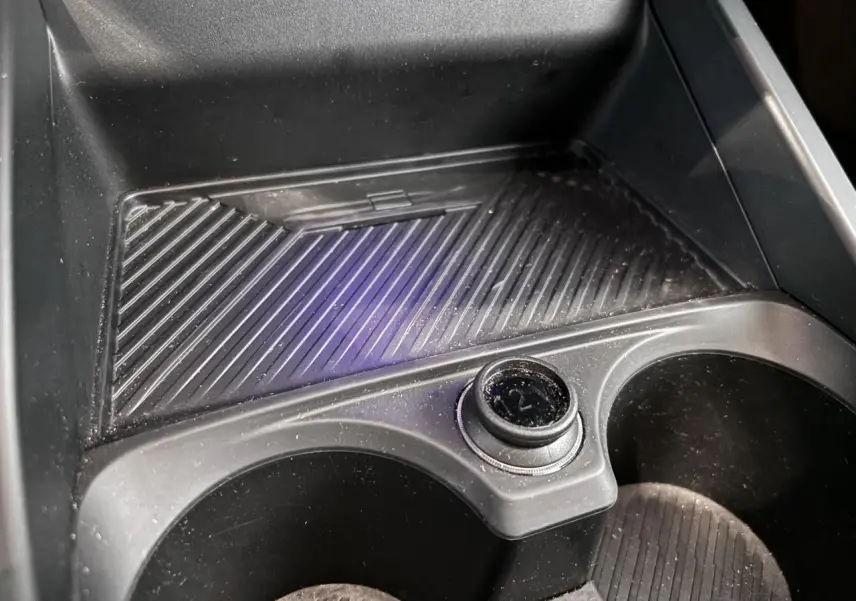 Gros plan sur le porte-gobelets intérieur noir de la BMW Série 1 120d M Sport 2025, avec prise 12V visible.