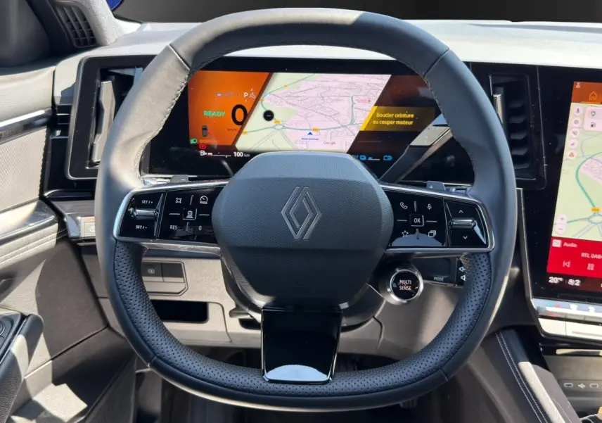 Vue rapprochée du volant noir et du tableau de bord numérique du Renault Rafale 2025 avec affichage multifonctions et écran tactile.