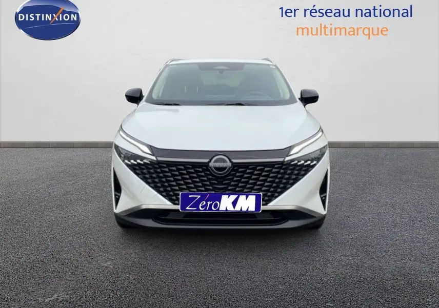 Vue frontale d'un Nissan Qashqai blanc nacré métal avec calandre noire texturée et phares LED fins.