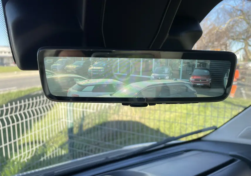 Rétroviseur intérieur affichant une vue arrière avec plusieurs véhicules stationnés, prise depuis un Peugeot Boxer Fourgon blanc.