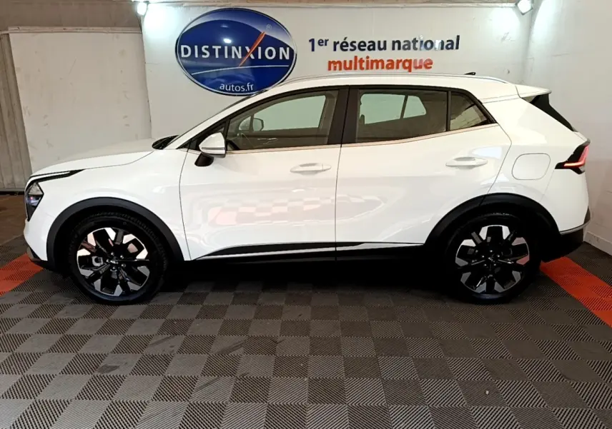 Vue latérale droite d'un KIA SPORTAGE blanc 2022 hybride rechargeable avec jantes noires et toit blanc.