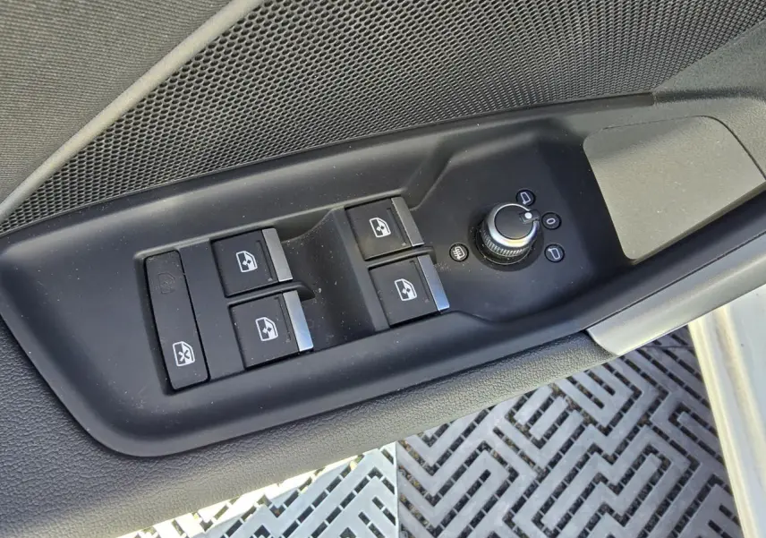 Gros plan sur la commande des vitres et rétroviseurs côté conducteur de l'Audi A3 Sportback blanc Arkona.