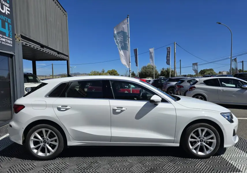 Profil latéral droit d'une Audi A3 Sportback 2024 en blanc Arkona avec jantes alliage 5 branches parallèles.