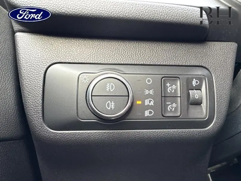 Gros plan sur les commandes d’éclairage du tableau de bord du Ford Kuga blanc Glacier 2021, avec réglages LED et antibrouillard.