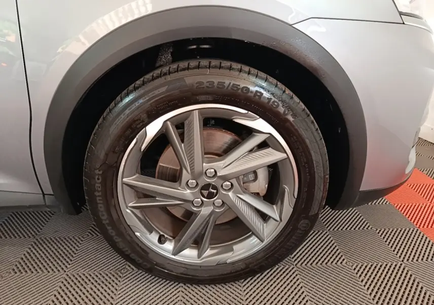 Gros plan sur la roue avant droite gris foncé du DS7 Crossback E-TENSE 225 BUSINESS avec jante alliage distinctive.