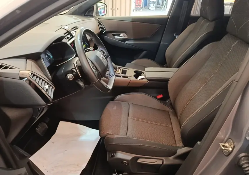 Intérieur avant droit du DS7 Crossback gris foncé, sièges tissu, volant cuir multifonctions et tableau de bord moderne.
