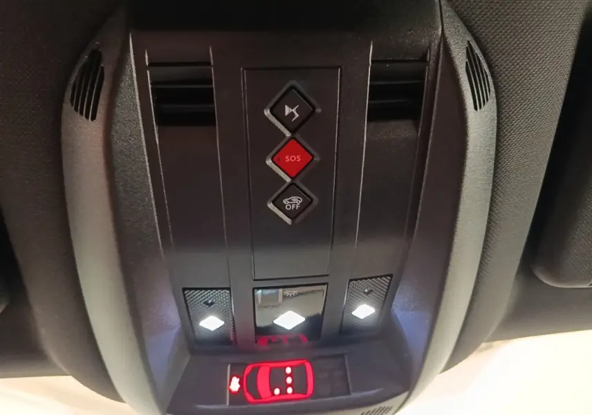 Gros plan sur la console de toit intérieure du DS7 Crossback E-TENSE 225, avec boutons SOS et éclairage LED allumé.