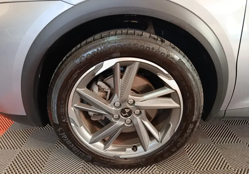 Gros plan sur la roue avant gauche gris foncé du DS7 Crossback E-TENSE 225 BUSINESS avec jante alliage distinctive.