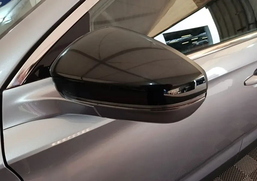 Rétroviseur extérieur noir en gros plan sur le côté gauche d’un DS7 Crossback gris foncé hybride rechargeable.