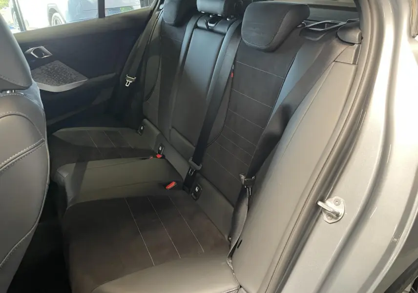 Vue intérieure côté droit des sièges arrière noirs en Alcantara et cuir d'une BMW Série 1 120d M Sport gris.