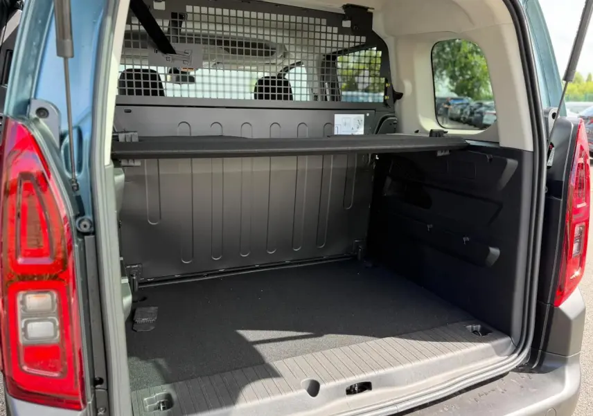 Coffre arrière ouvert du Citroën Berlingo Multispace bleu Kiama, avec lunette arrière ouvrante et séparation grillagée.