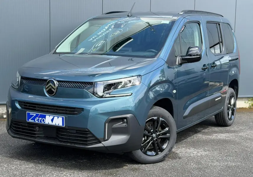 Vue 3/4 avant droite du Citroën Berlingo Multispace 2026 bleu Kiama avec jantes alliage noires et barres de toit.