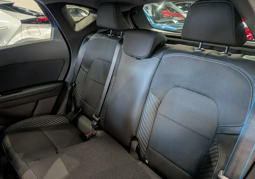 Vue intérieure des sièges arrière en cuir noir avec surpiqûres bleues du Renault Captur E-TECH Full Hybrid 2025.