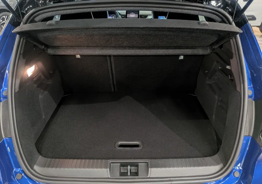 Coffre ouvert vu de l'arrière du Renault Captur E-TECH bleu Iron avec intérieur noir et éclairage latéral.