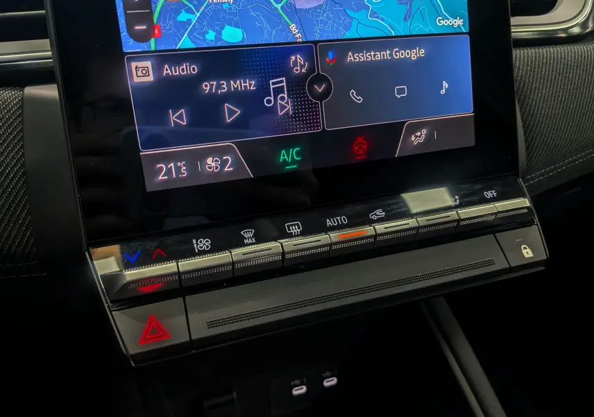 Détail de la console centrale du Renault Captur E-TECH 2025, avec écran tactile affichant navigation et commandes climatisation.
