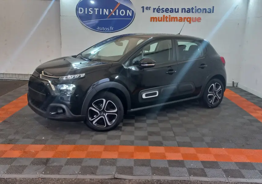 Citroën C3 noire vue de profil droit en intérieur, avec jantes distinctives et airbumps blancs sur les portières.