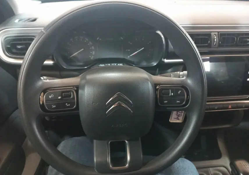 Vue frontale du volant noir de la Citroën C3 2024 avec commandes intégrées et tableau de bord digital.