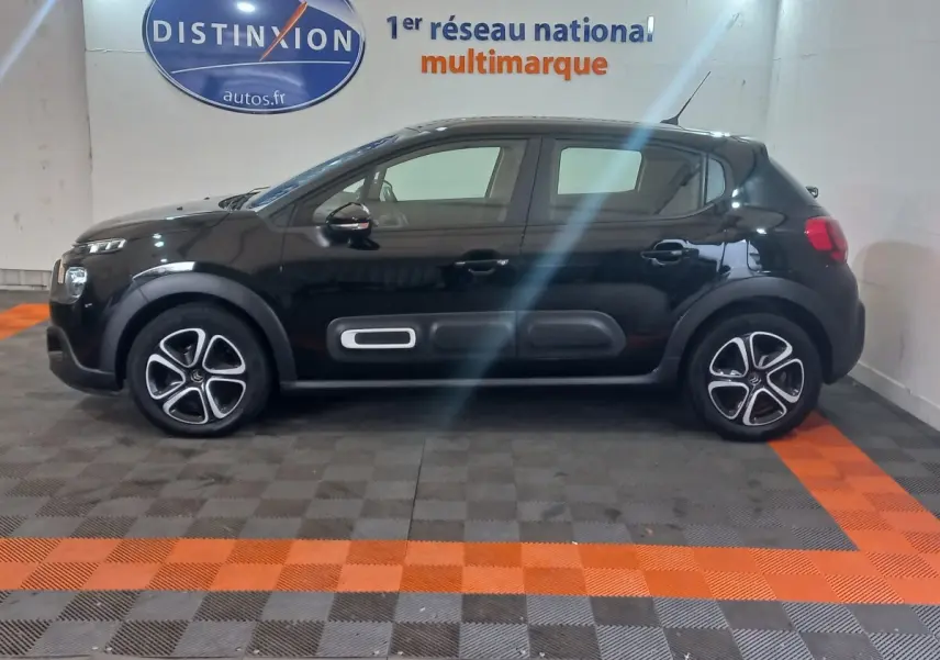Profil droit d'une Citroën C3 noire 2024 avec protections latérales distinctives et jantes stylisées en concession.