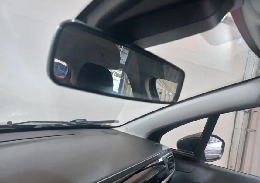 Vue intérieure du tableau de bord et rétroviseur central d'une Citroën C3 noire, angle côté passager.