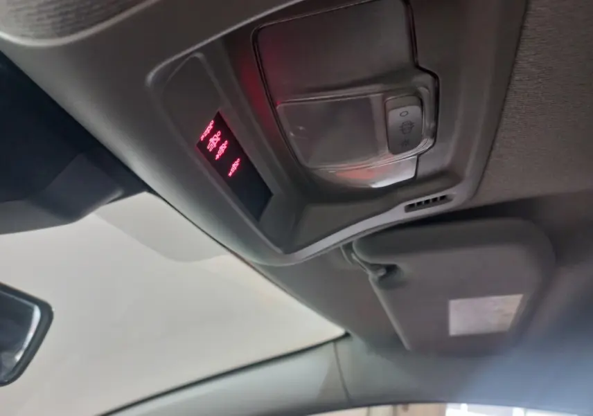 Vue intérieure du plafond avant de la Citroën C3 noire 2024, montrant la console de plafonnier avec éclairage rouge et commandes.