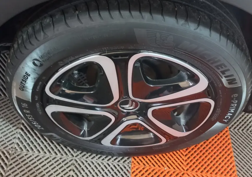 Gros plan sur la roue avant droite noire d'une Citroën C3 2024 avec jante alliage et pneu Michelin visible.
