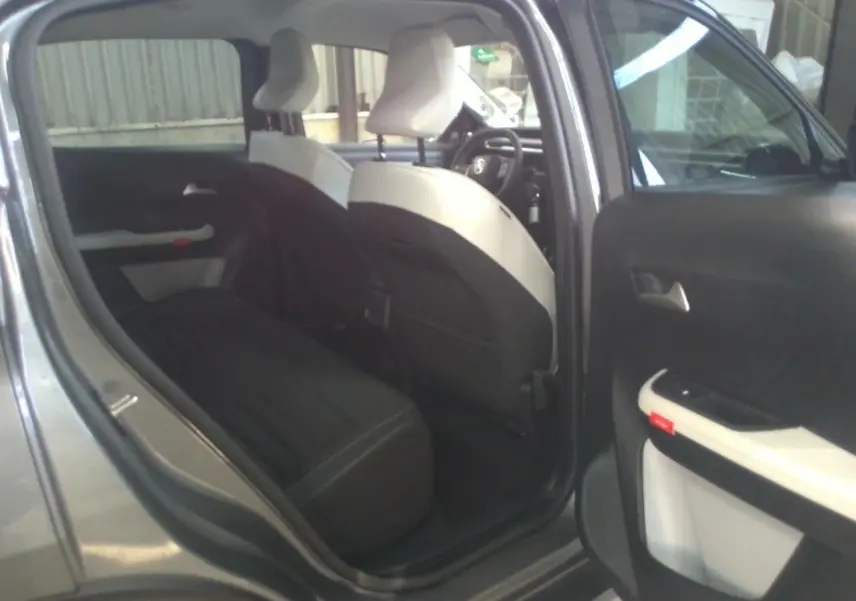 Vue intérieure côté gauche montrant la banquette arrière noire et les sièges avant bicolores du Citroën C3 Aircross gris Mercury.