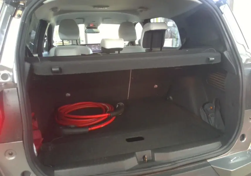 Coffre ouvert d’un Citroën C3 Aircross électrique gris Mercury, avec câble de recharge rouge visible à l’intérieur.