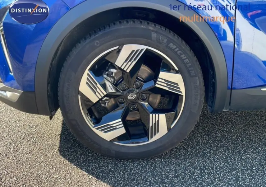 Gros plan sur la roue avant gauche du Renault Symbioz bleu, jante aluminium noire et argentée au design moderne.