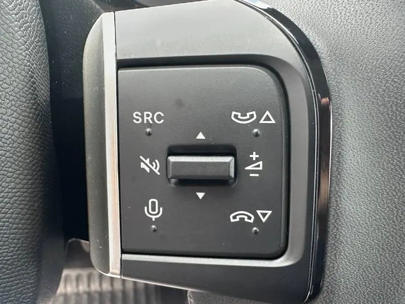 Gros plan sur les commandes audio et téléphone au volant de la Citroën C3 gris Mercury, intérieur noir.