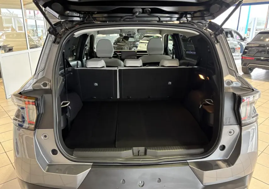Coffre ouvert vue arrière du Citroën C3 Aircross gris avec banquette arrière noire et sièges blancs visibles.