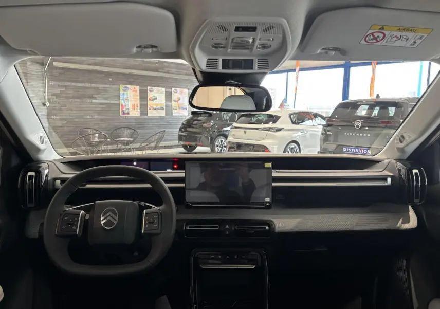 Vue intérieure avant du tableau de bord noir et gris avec écran tactile central et volant multifonctions Citroën C3 Aircross 2026.