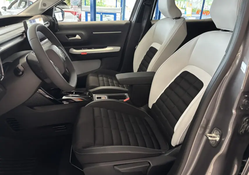 Vue intérieure côté conducteur du Citroën C3 Aircross 2026, sièges bicolores noir et blanc, volant multifonctions.