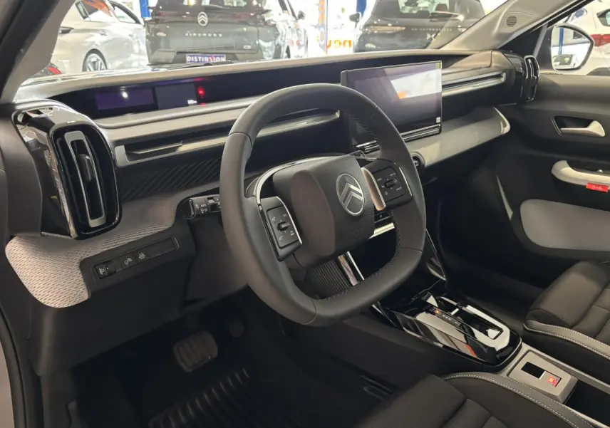 Vue intérieure côté conducteur du Citroën C3 Aircross 2026, volant carré et tableau de bord moderne noir et gris.