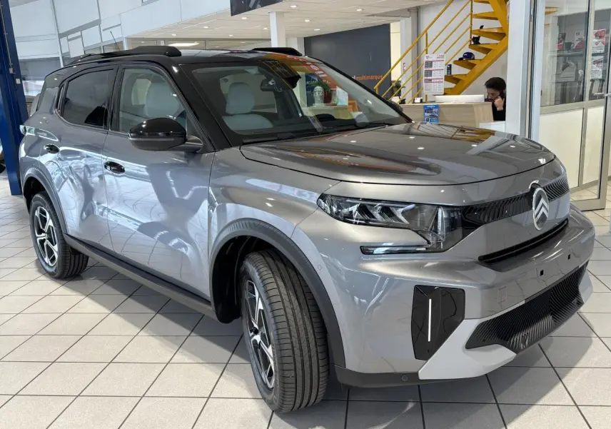 Vue 3/4 avant droite du Citroën C3 Aircross 2026 gris métallisé avec toit noir et jantes alliage diamantées.