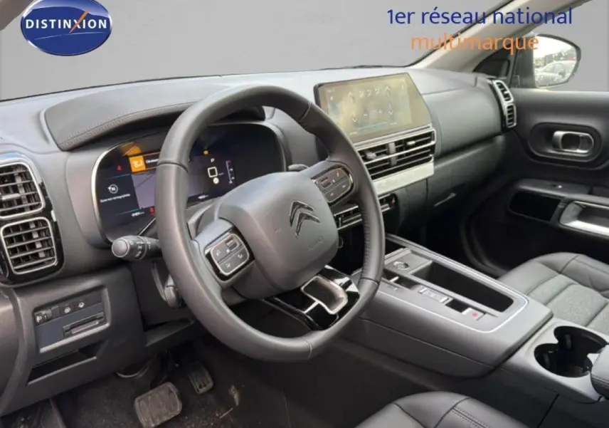 Vue intérieure côté conducteur du Citroën C5 Aircross 2025, montrant le volant cuir multifonctions et l'écran tactile central.