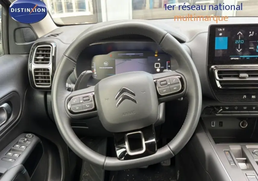 Vue intérieure centrée sur le volant cuir multifonctions et le cockpit numérique du Citroën C5 Aircross 2025.