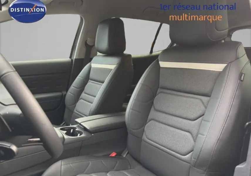 Vue intérieure côté conducteur du Citroën C5 Aircross 2025, sièges en cuir et tissu gris avec accoudoir central.