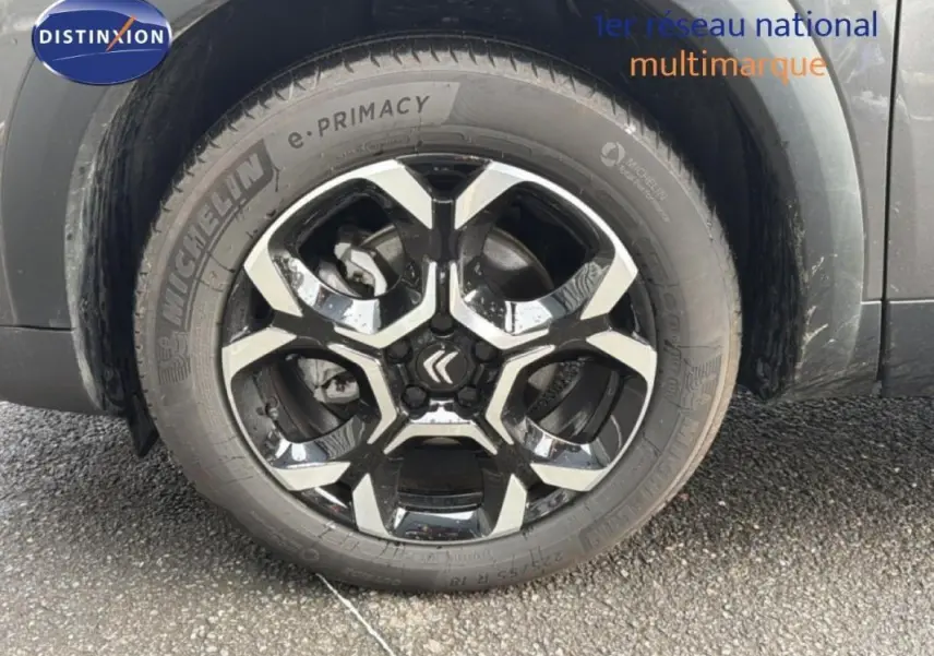 Gros plan sur la jante aluminium noire et argentée du côté gauche d'un Citroën C5 Aircross platine 2025.