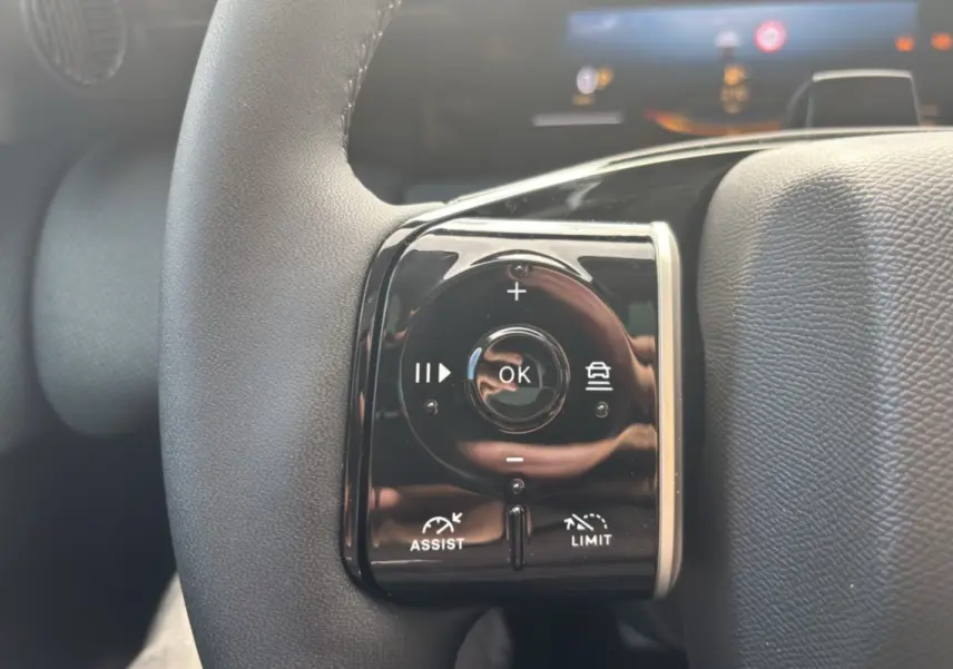 Gros plan sur les commandes noires multifonctions au volant cuir du Citroën C5 Aircross blanc avec toit noir.