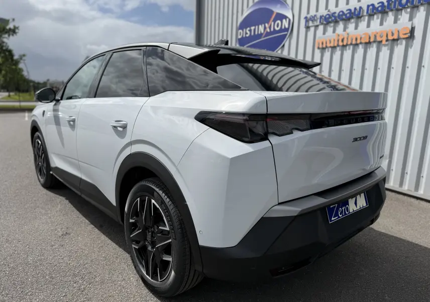 Vue 3/4 arrière droite du Peugeot 3008 Hybrid blanc Okenite avec toit noir et jantes noires distinctives.