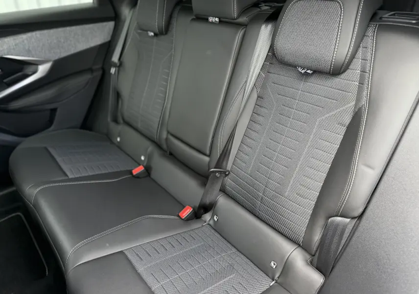 Vue intérieure des sièges arrière en cuir noir et tissu gris du Peugeot 3008 Hybrid 2026, côté droit visible.