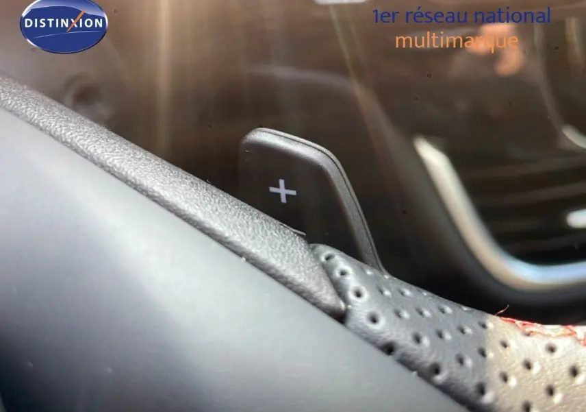 Gros plan sur la palette de changement de vitesse "+" côté droit du volant perforé d'un Ford Puma noir Agate Metal 2023.