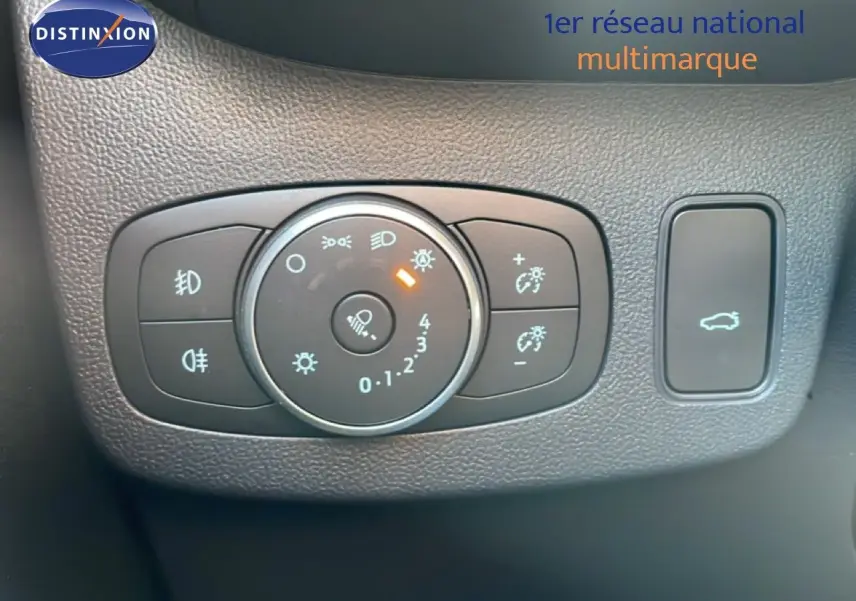 Gros plan sur les commandes d’éclairage et ouverture du coffre du Ford Puma noir agate métal, intérieur tableau de bord.